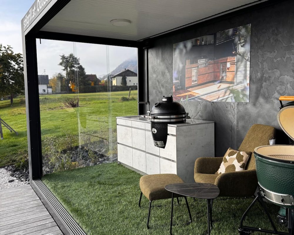 Outdoorküche im Schauraum mit MONOLITH Kamado-Grill, Küchenblock und Sitzbereich.