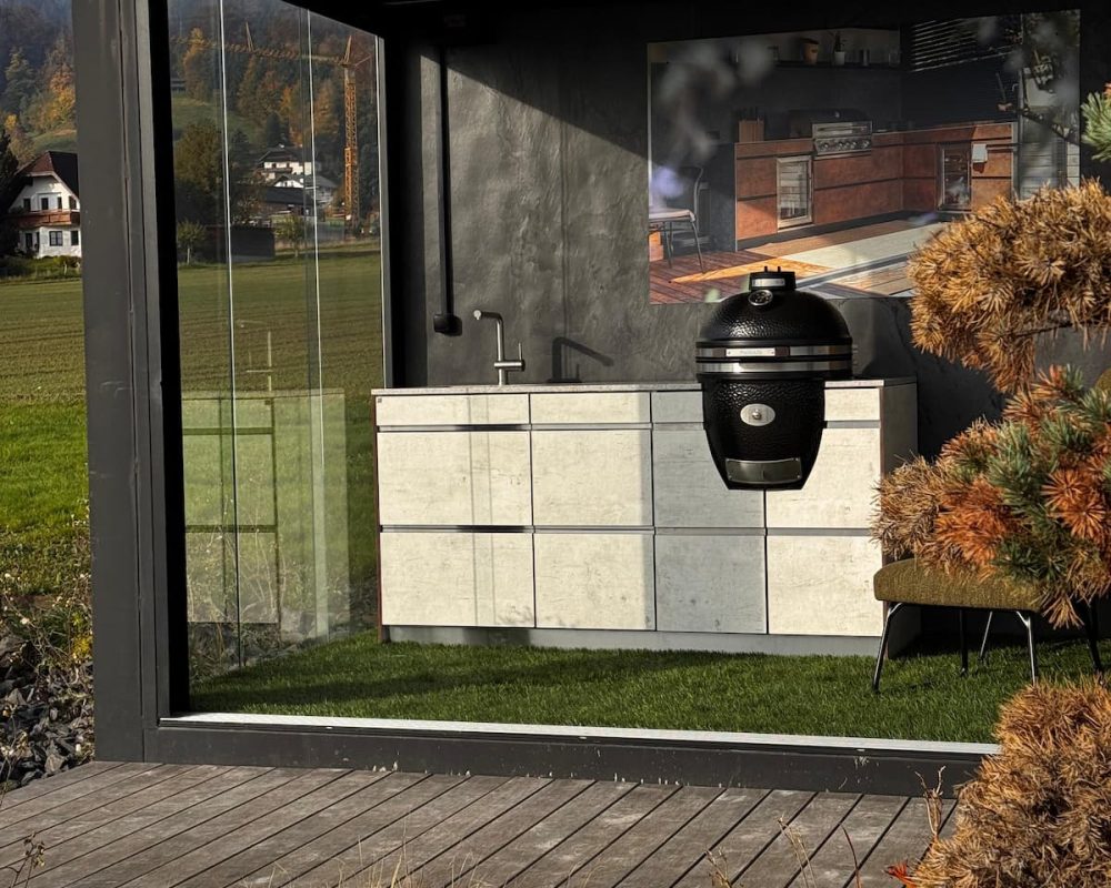 Schauraum-Container mit Schriftzug stilgrill.at, innen eine Outdoorküche mit MONOLITH Kamado-Grill.